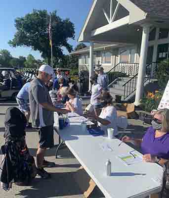 Several women at a table with a male golfer.