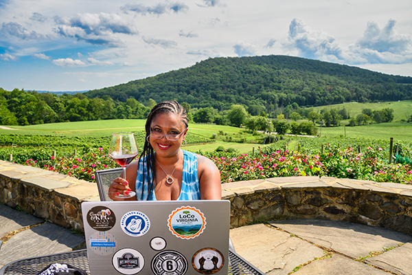 Woman sitting at a computer at a vineyard.