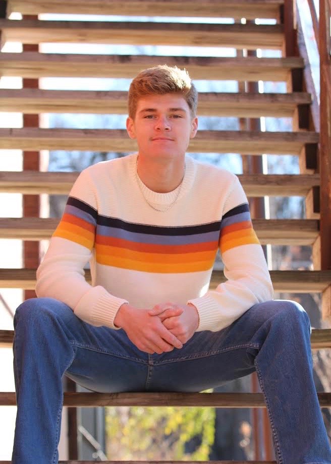 high school male sitting on stairs for a senior photo
