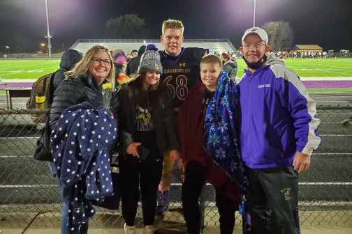 family with football player after a football game
